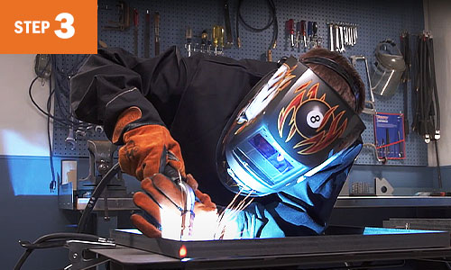 Operator MIG welds on the frame.