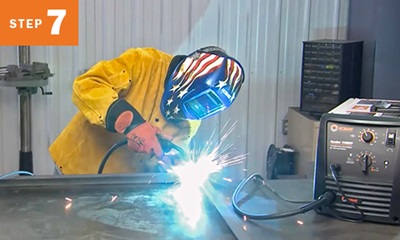 Welder welding two pieces of metal together