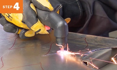cutting out a pattern traced on metal with a plasma cutting torch