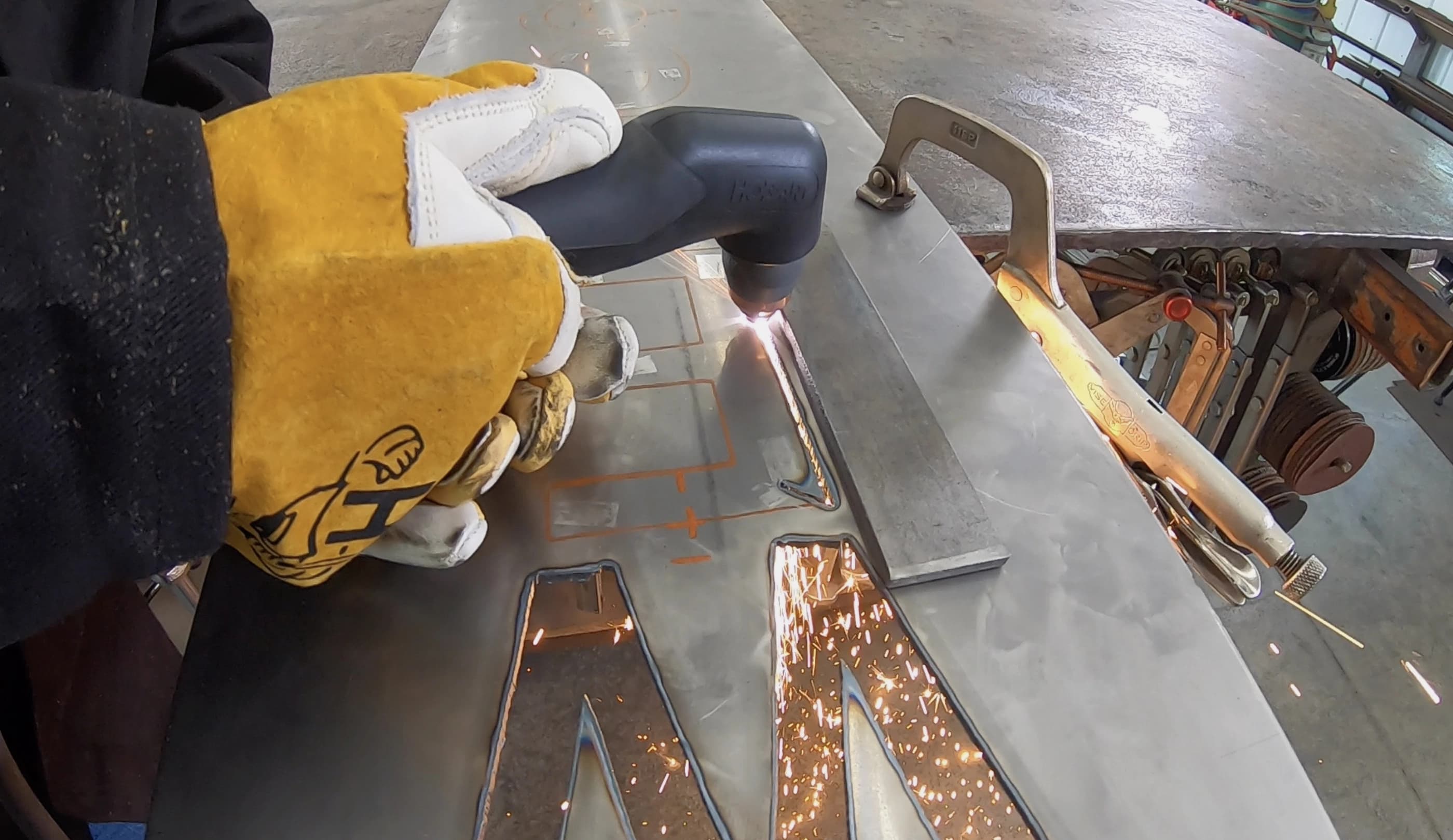 Welder cutting metal using a Hobart Welding Products Airforce 27i plasma cutter